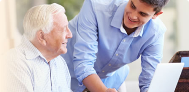 Man helping an older man with technology